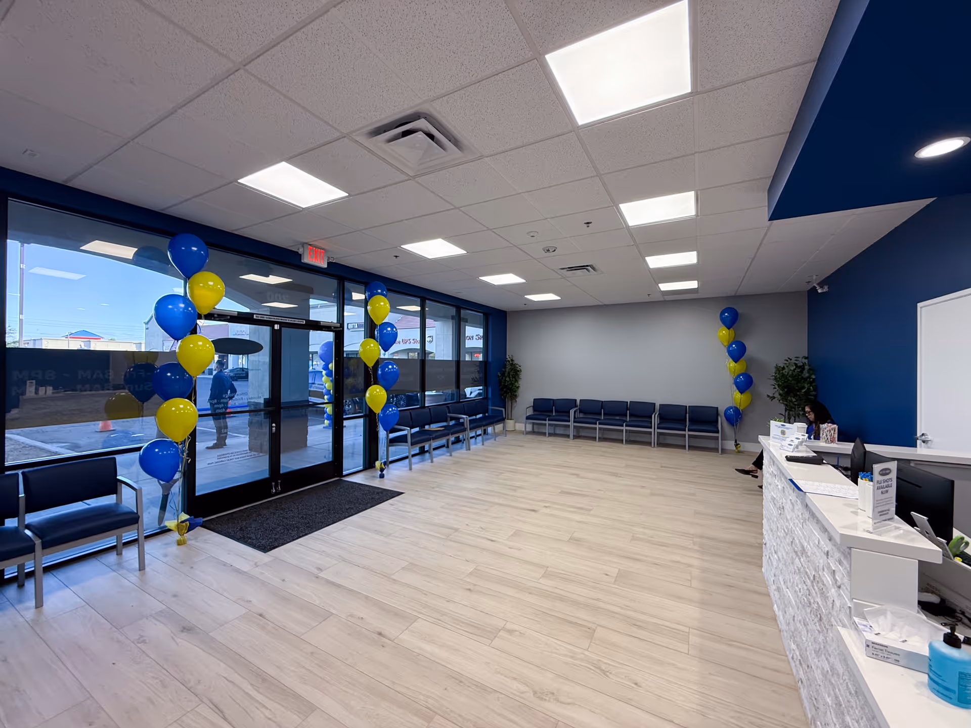Lobby area with blue chairs, balloons, and a glass entrance.