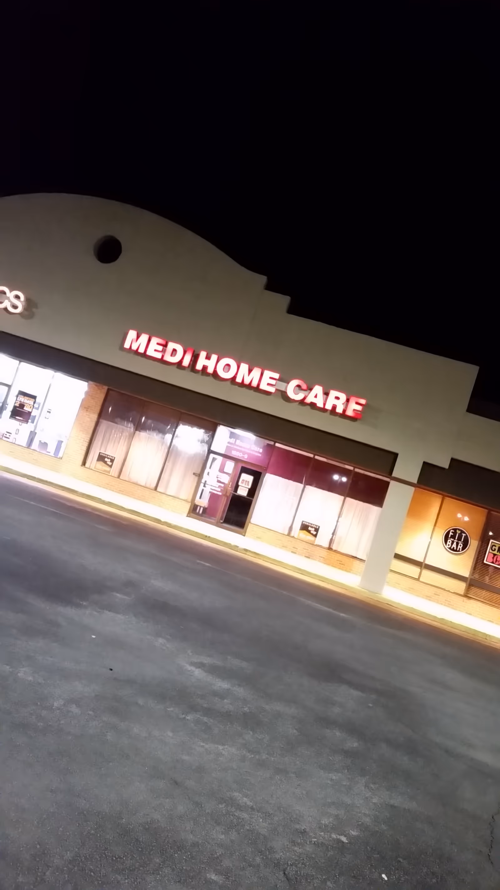 Night exterior of Medi Home Care storefront with illuminated sign.
