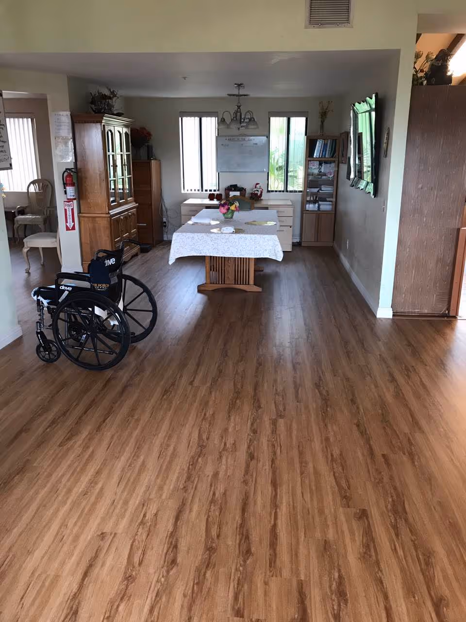 Interior common area of Mountain View Manor Assisted Living with a wheelchair, table, and cabinets.