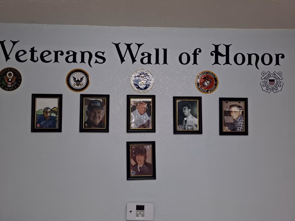 Interior wall displaying framed veteran portraits under 'Veterans Wall of Honor'.
