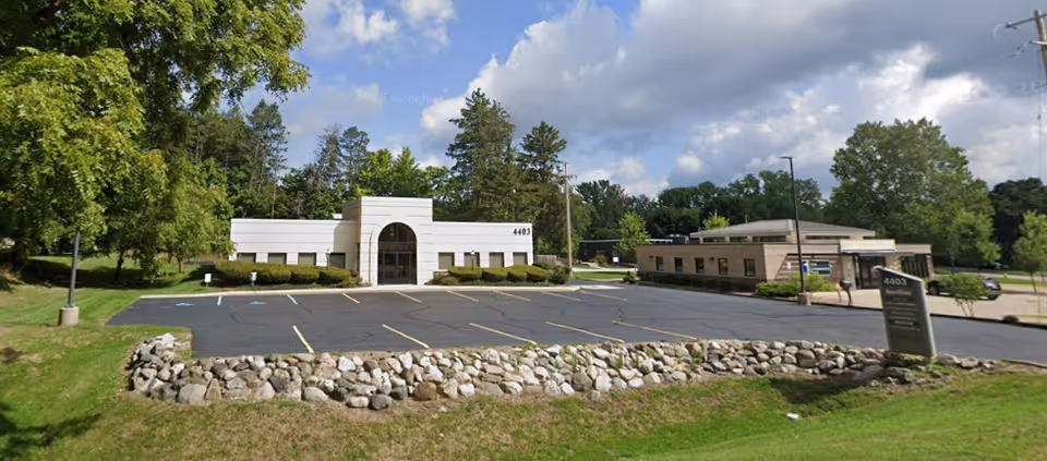 Exterior view of a Senior Helpers facility with a parking lot and entrance.