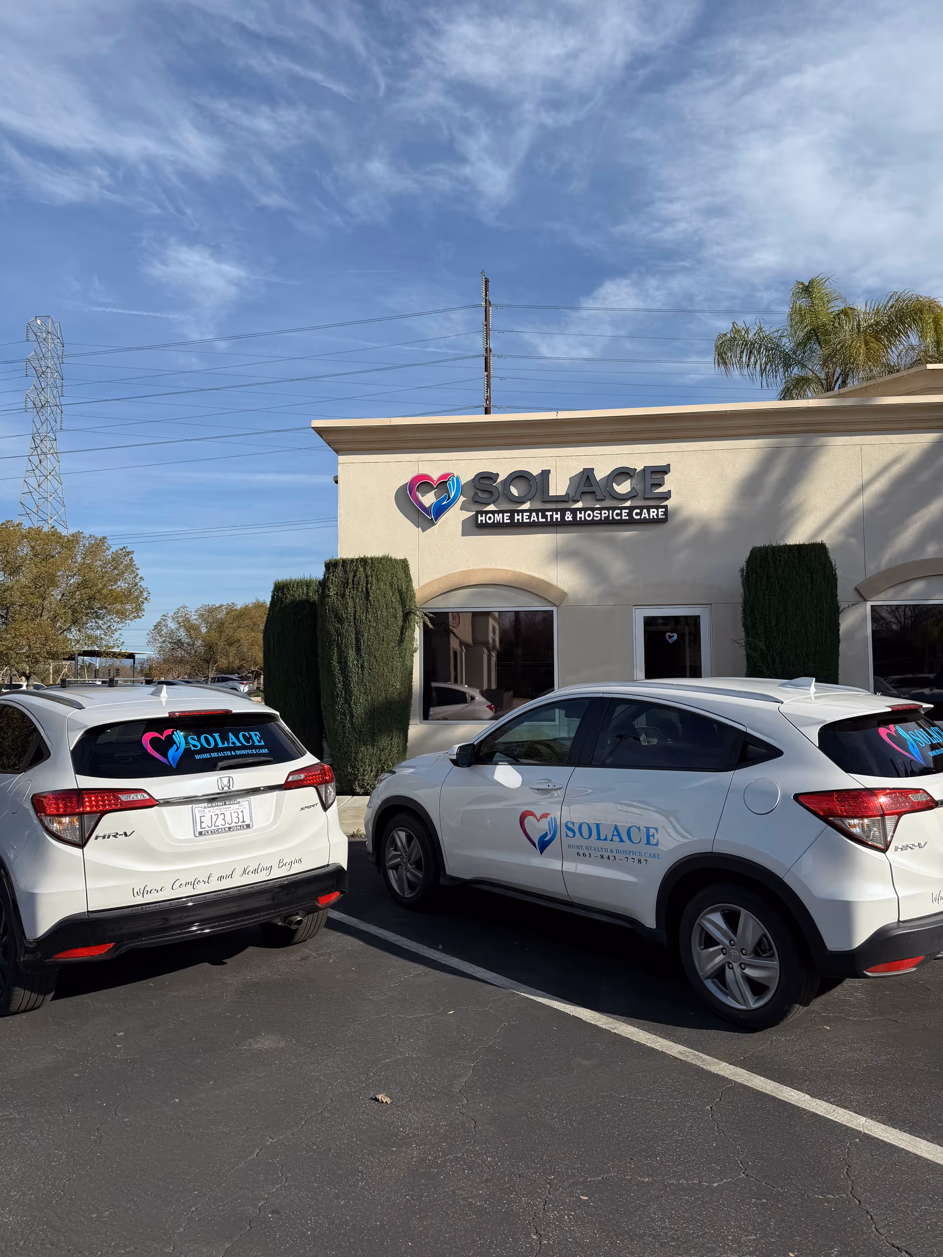 Exterior view of Solace Home Health & Hospice Care building with parked company vehicles