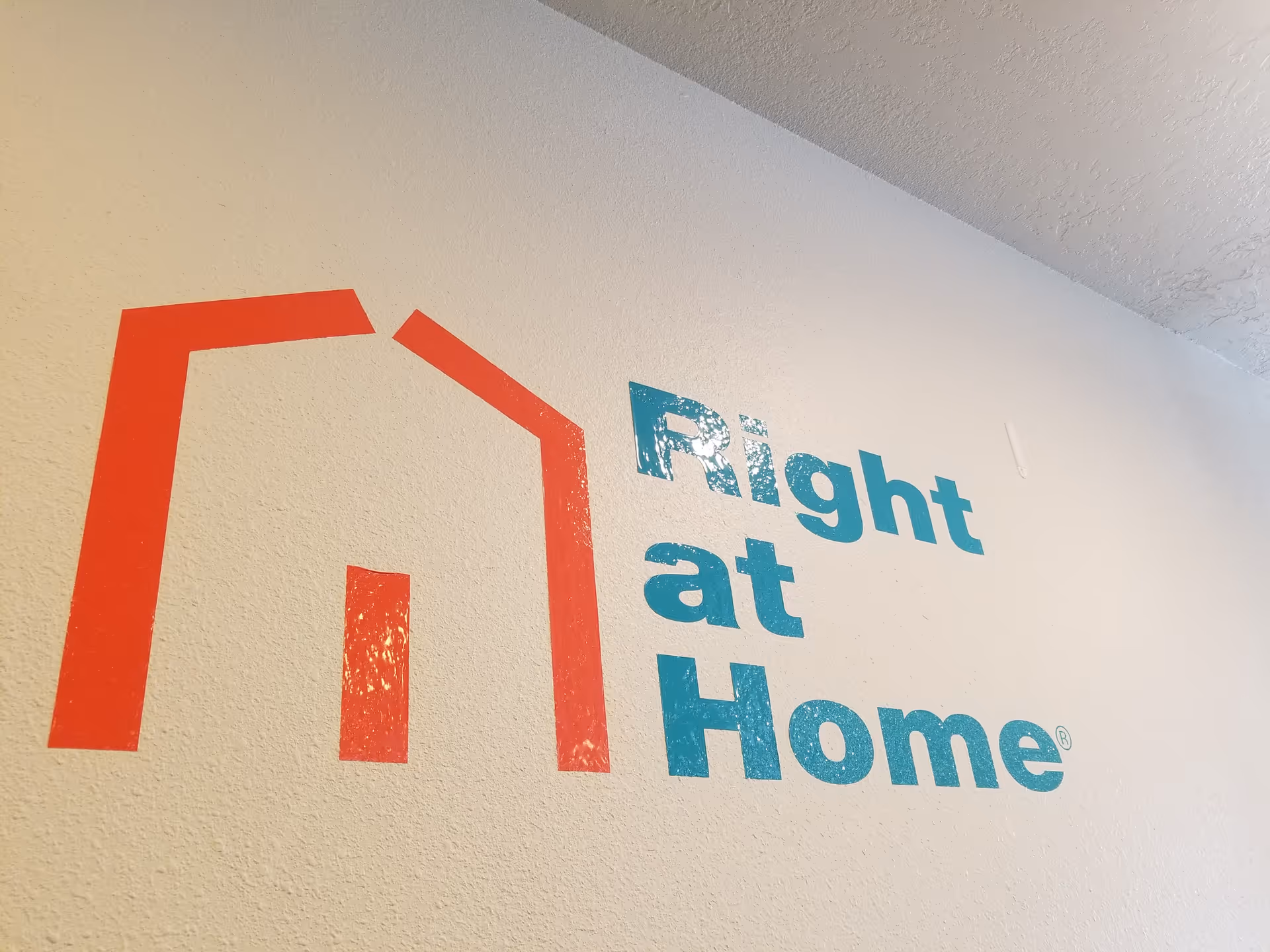 Interior wall with Right at Home logo and red house icon.