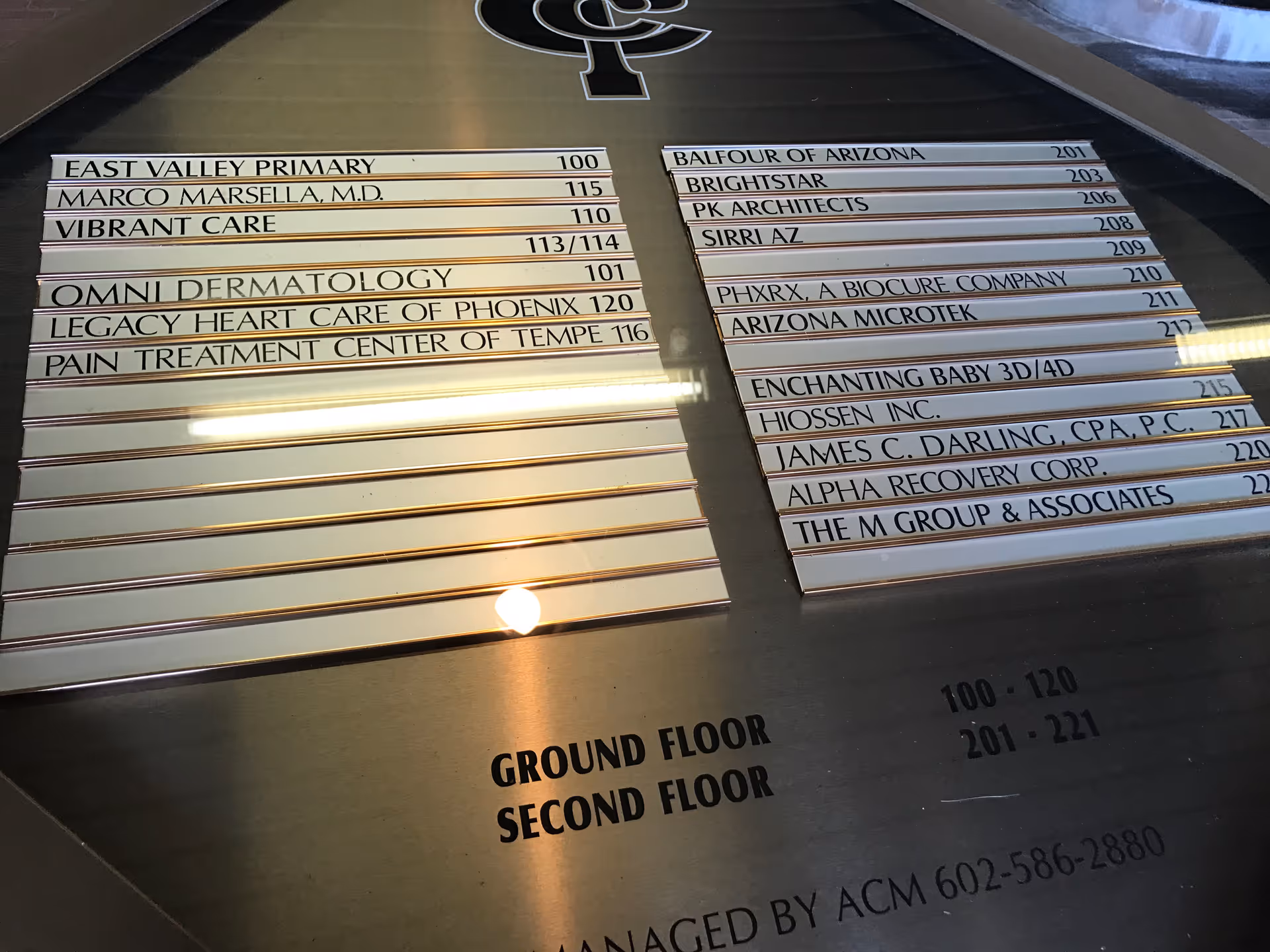 Interior directory sign panels listing office names and floor levels on two floors.