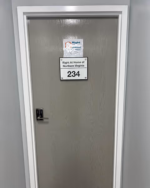 Gray interior door labeled 234 with Right at Home signage in a hallway