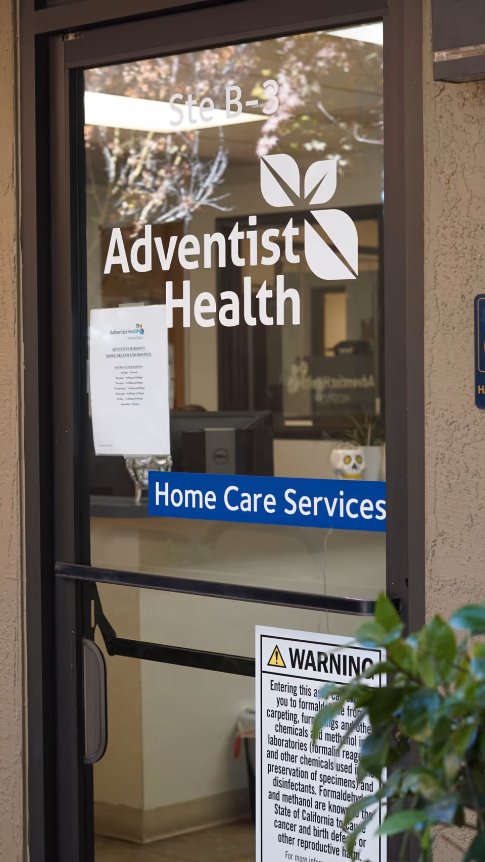 Glass entrance door displaying Adventist Health logo and blue Home Care Services sign.