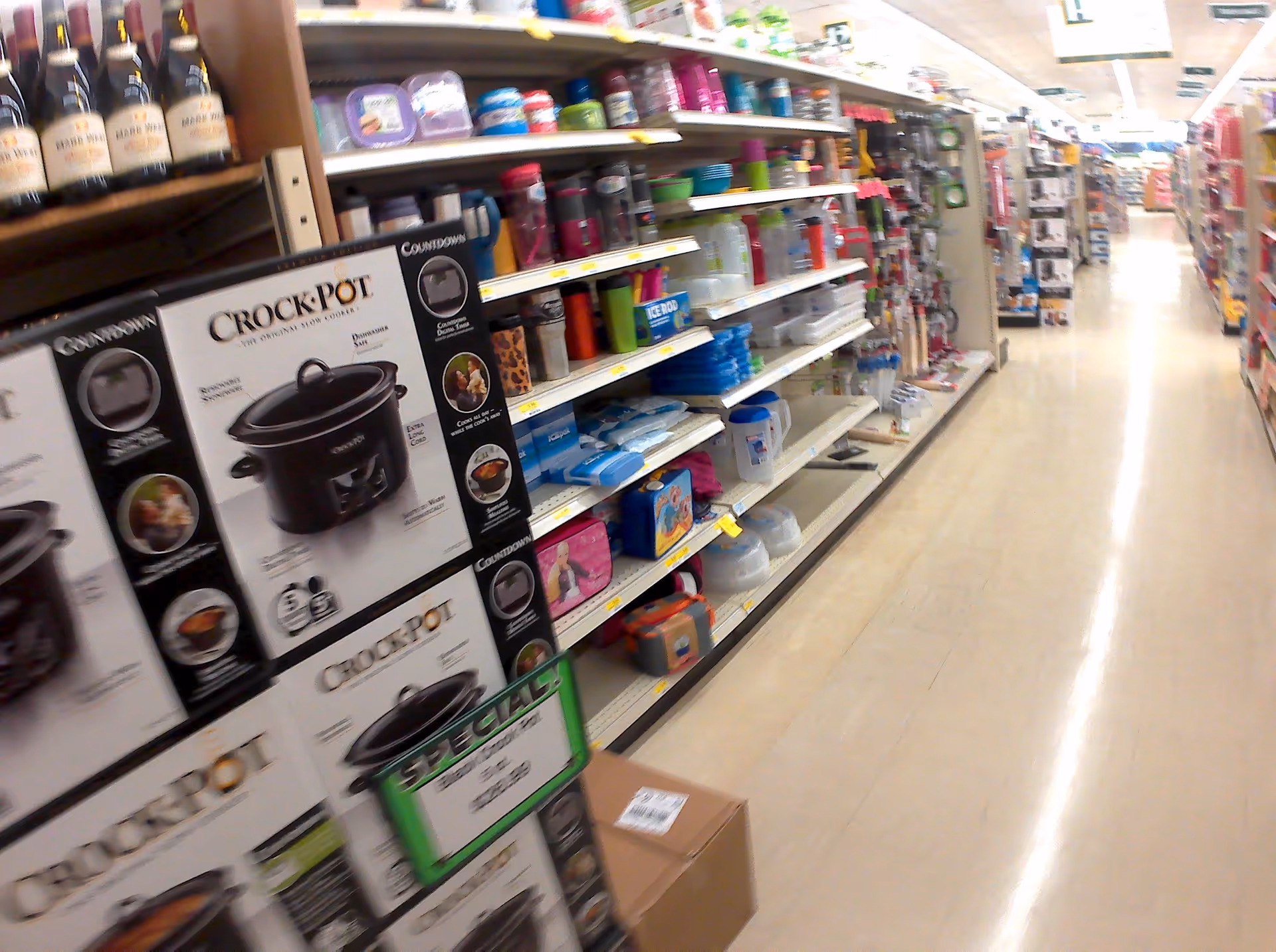 A store aisle with shelves stocked with kitchen appliances and housewares