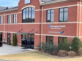 Exterior brick facility with large arched windows and entrance facing the viewer.