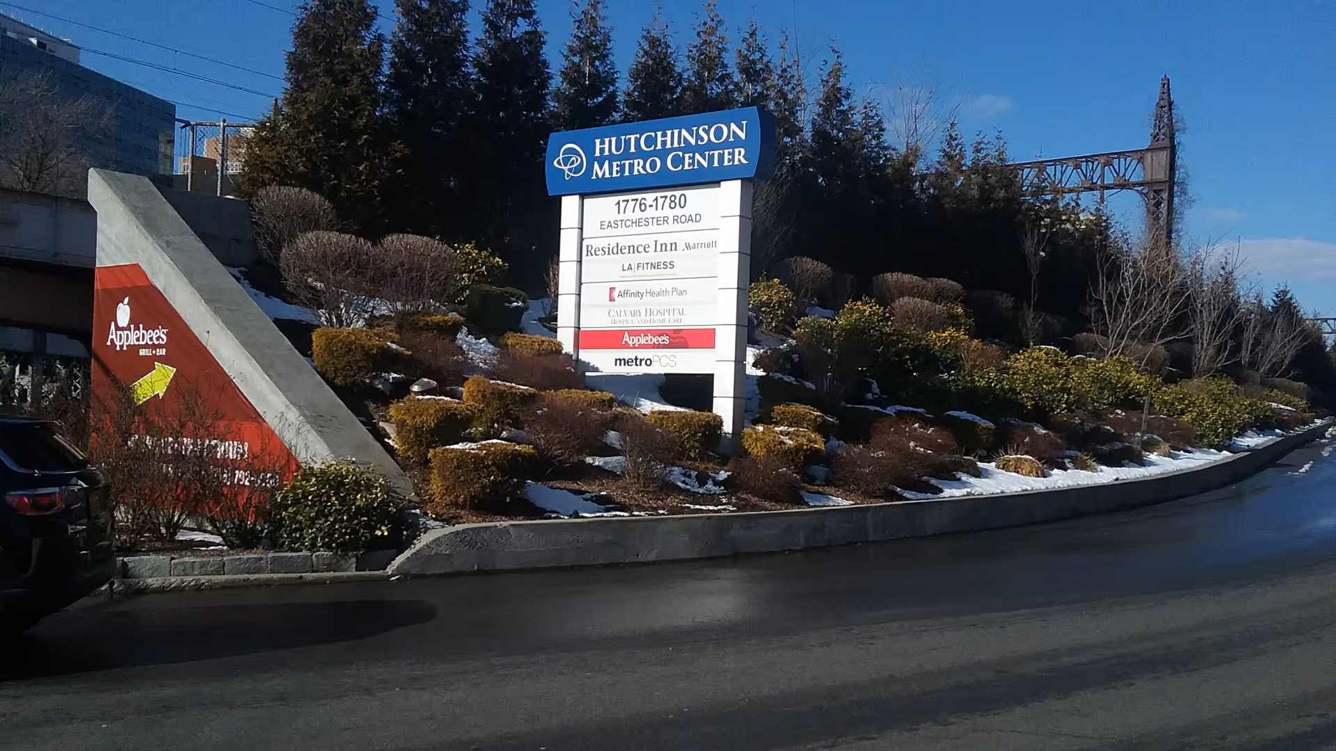 Wide view of a landscaped median with a large Hutchinson Metro Center sign.