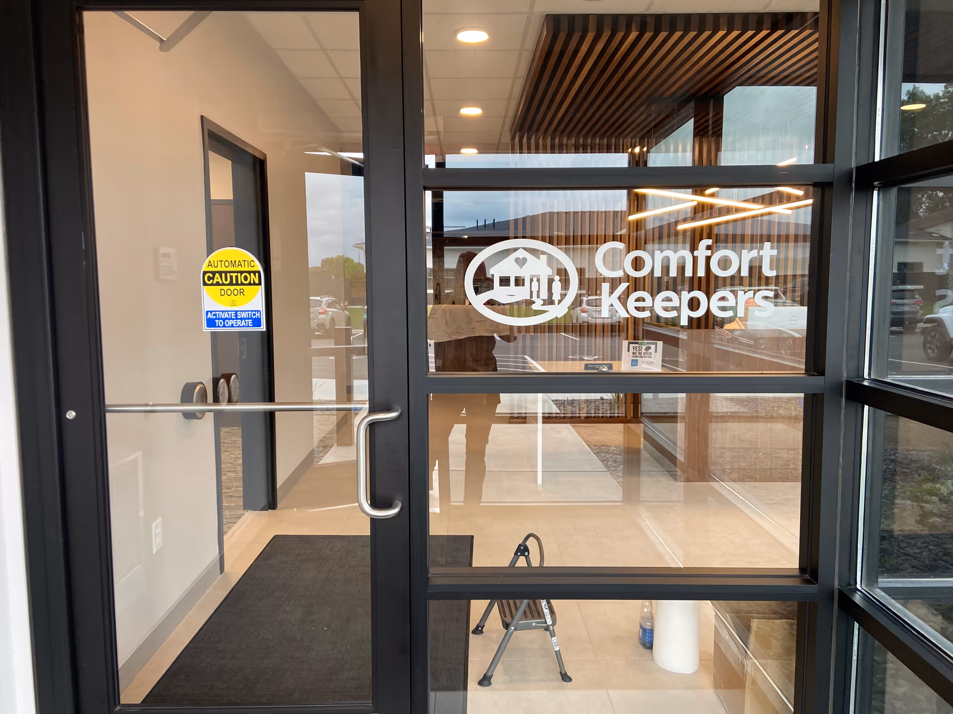 Glass entrance doors with Comfort Keepers logo; interior lobby visible beyond.