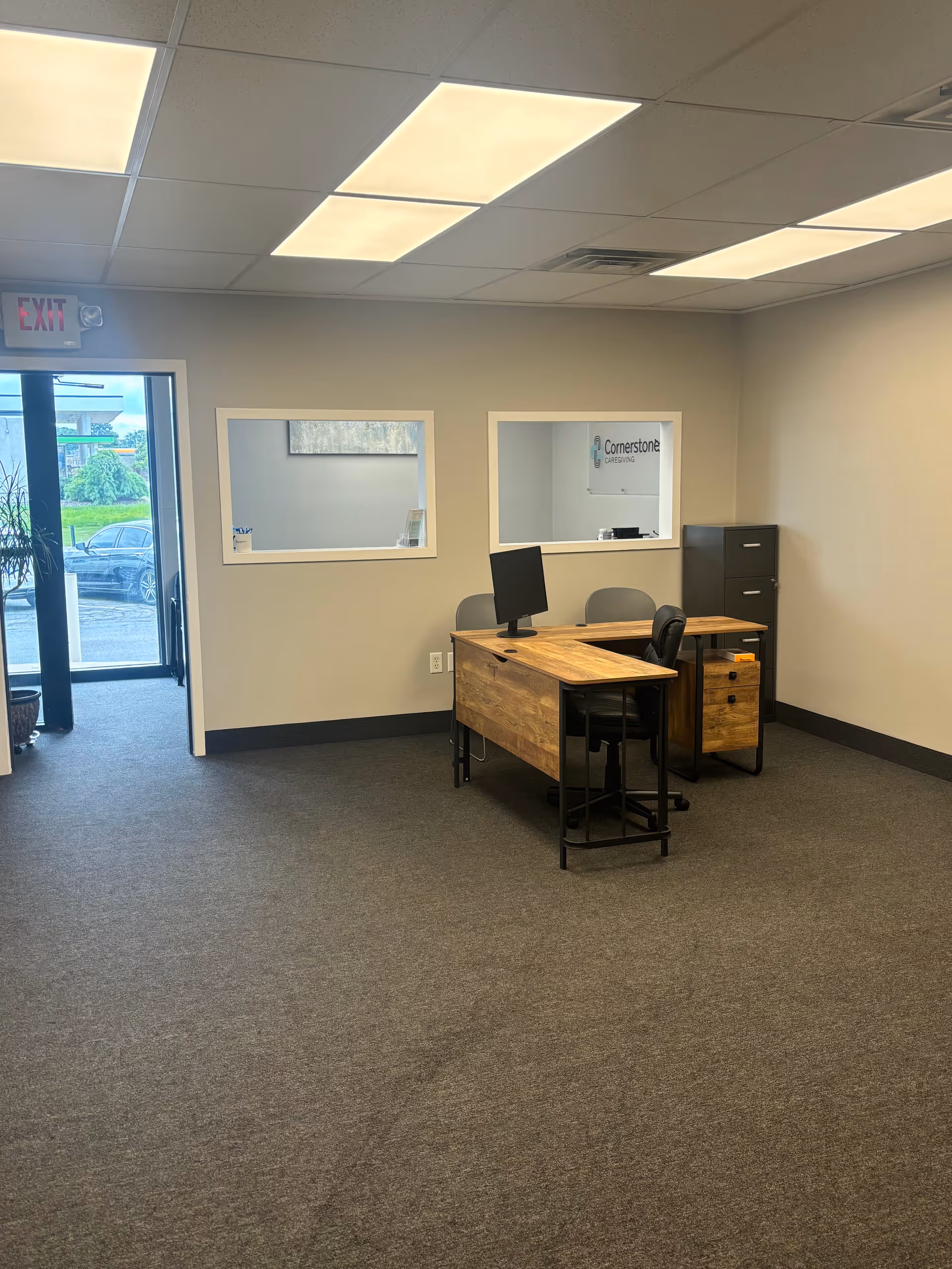 Interior office space at Cornerstone Caregiving with desk, computer, and filing cabinet.