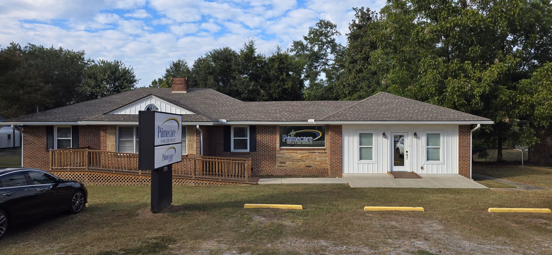 Single-story brick facility with Primecare sign, white entry doors, and a parking lot.