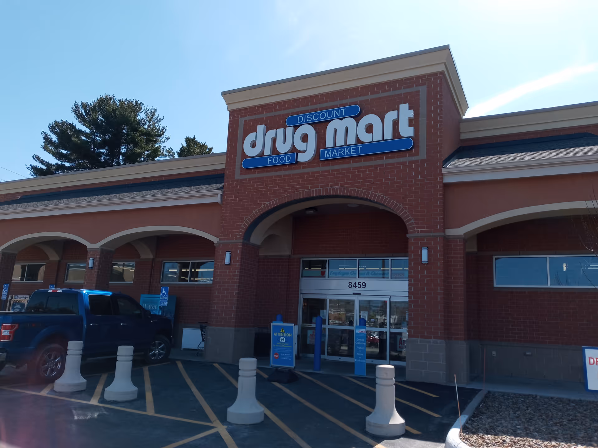 Exterior view of a Discount Drug Mart storefront with sign and parking.