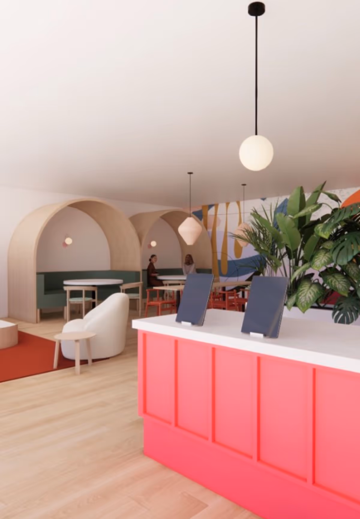 Bright modern indoor lobby with a pink reception desk, curved booths, and plants.