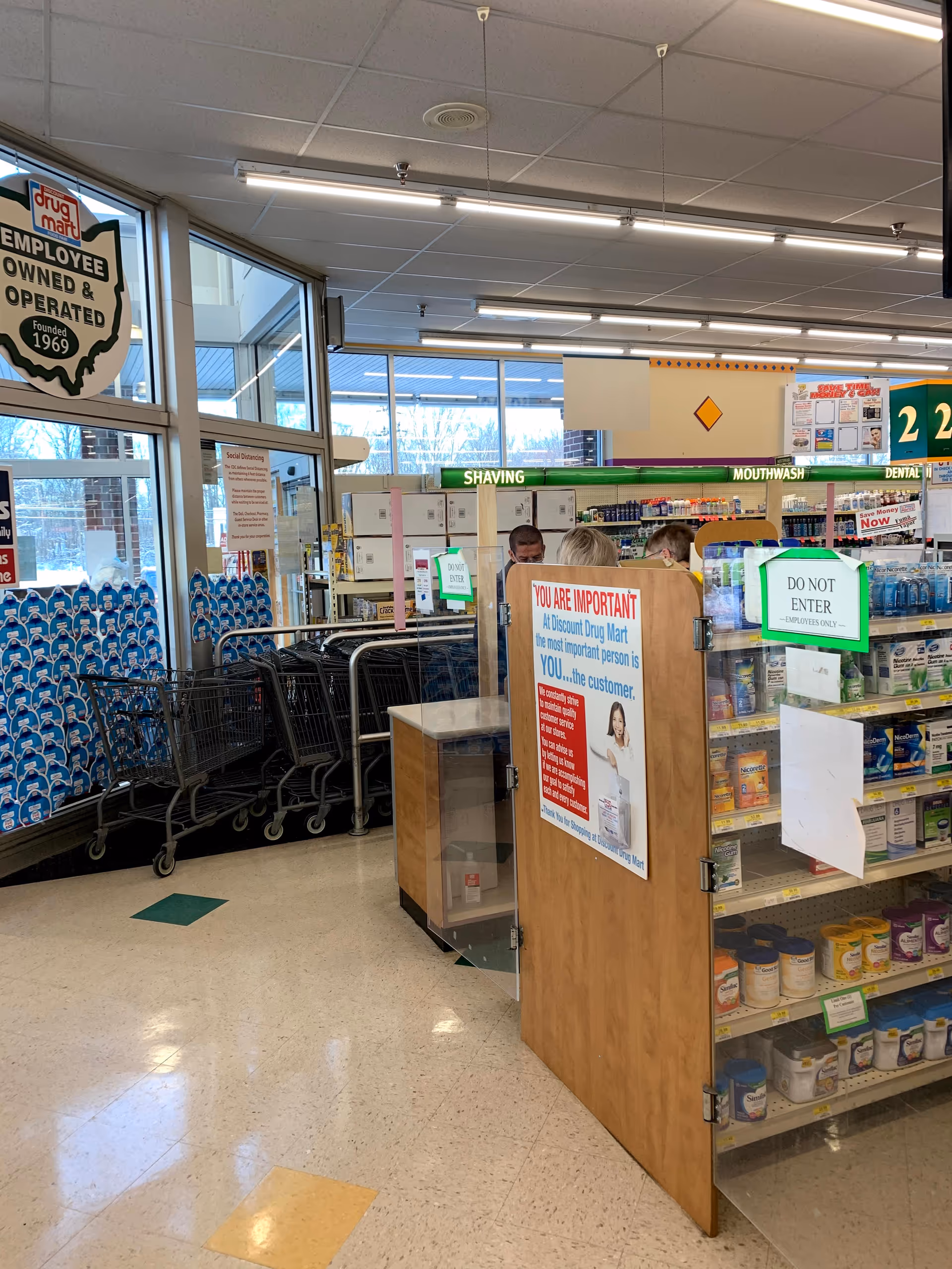 Inside Discount Drug Mart store with shopping carts, shelves, and a front counter.