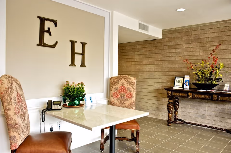 Interior lobby with marble table, upholstered chairs, and decorative Editha House signage.