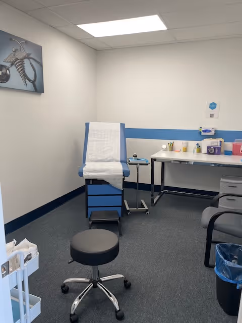 Examination chair with paper cover in a small clinical room.
