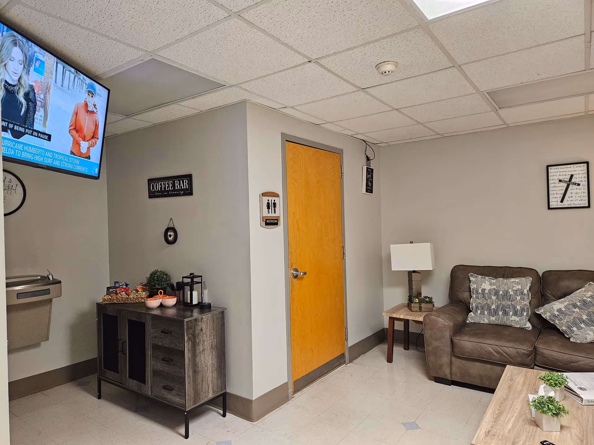 Brightmoor Hospice lounge with brown leather sofa, coffee table, side table lamp, and coffee bar.