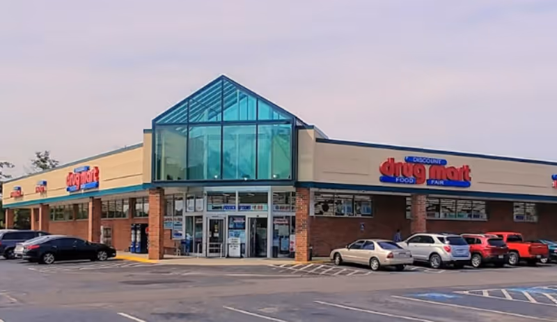 Discount Drug Mart storefront with glass entrance and parking lot.