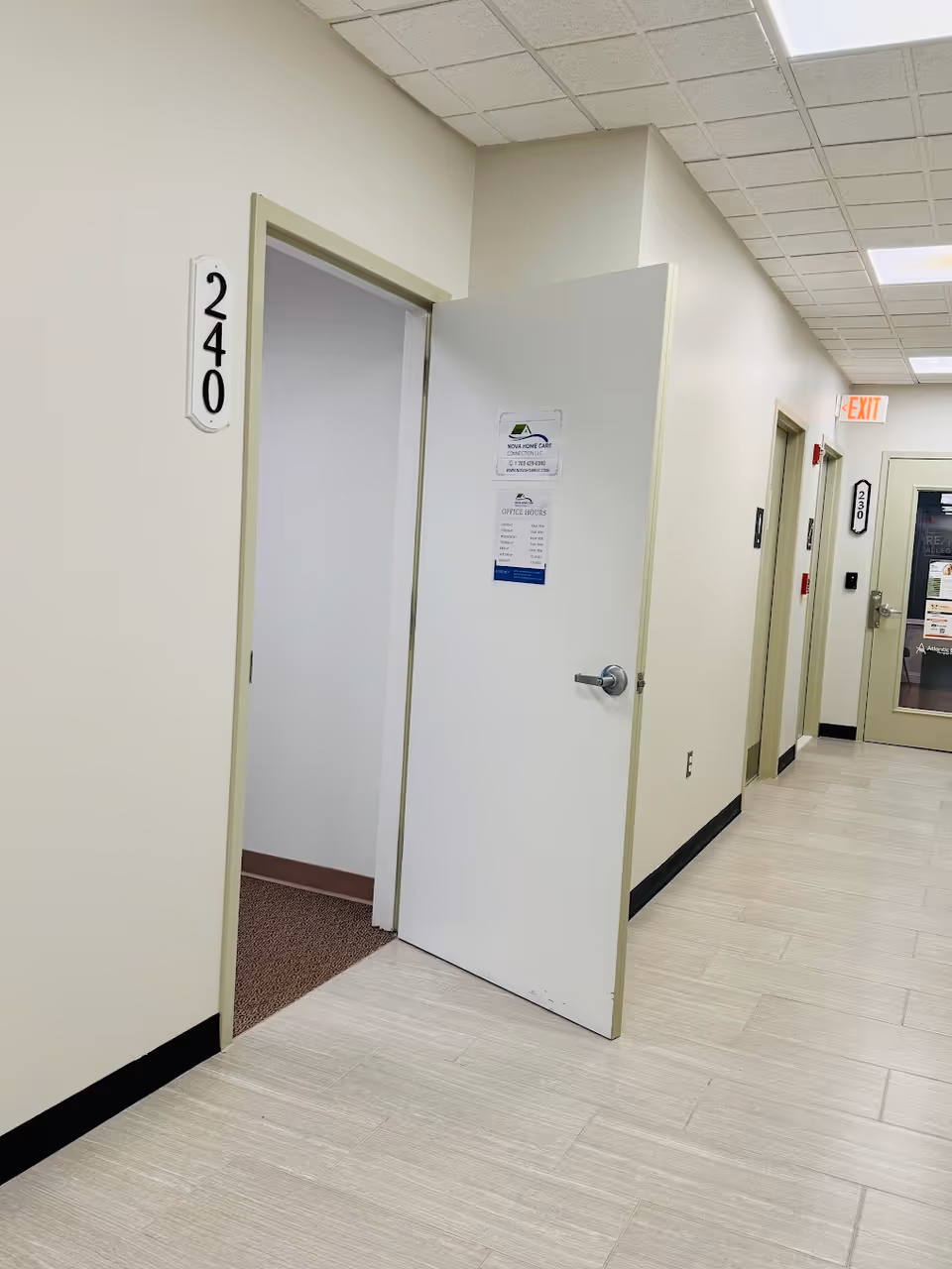 Interior corridor of a senior living facility with open doors and unit numbers.