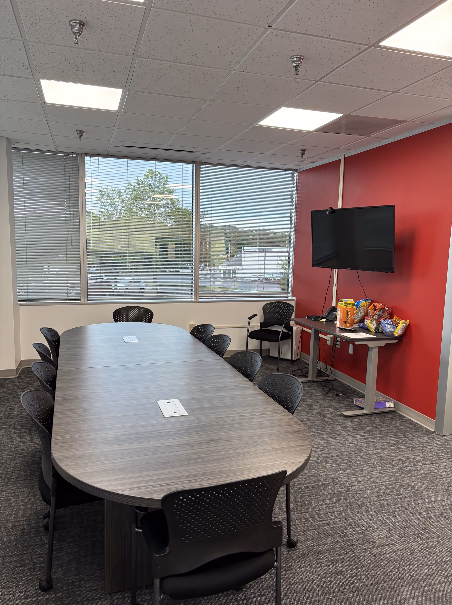 Meeting room in BAYADA Home Health with an oval table, chairs, and TV.