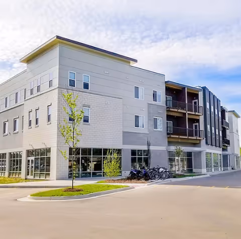 Exterior view of a modern senior home care facility with bike racks.