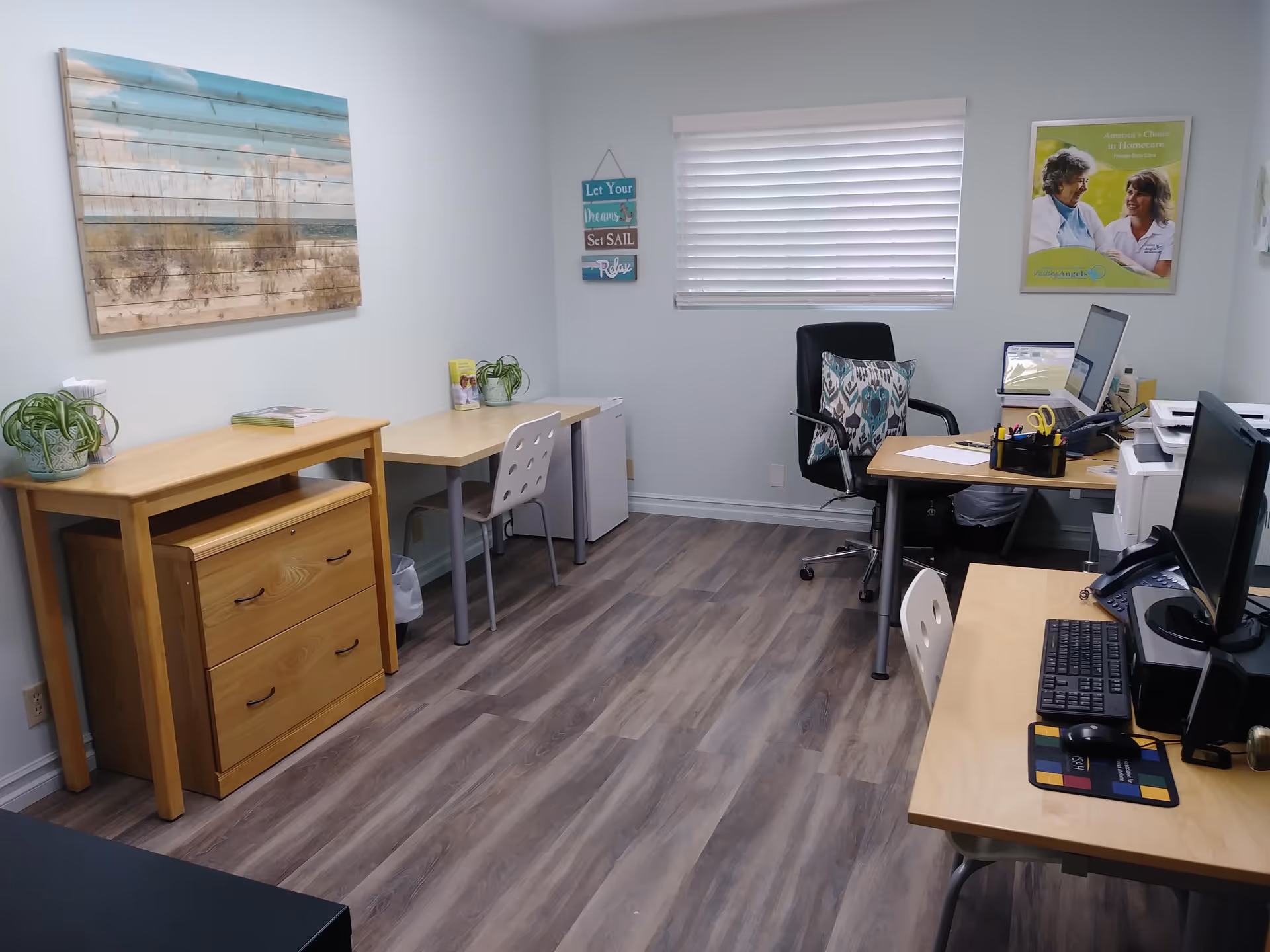 Office workspace in a Visiting Angels senior home care facility with desks and computers.