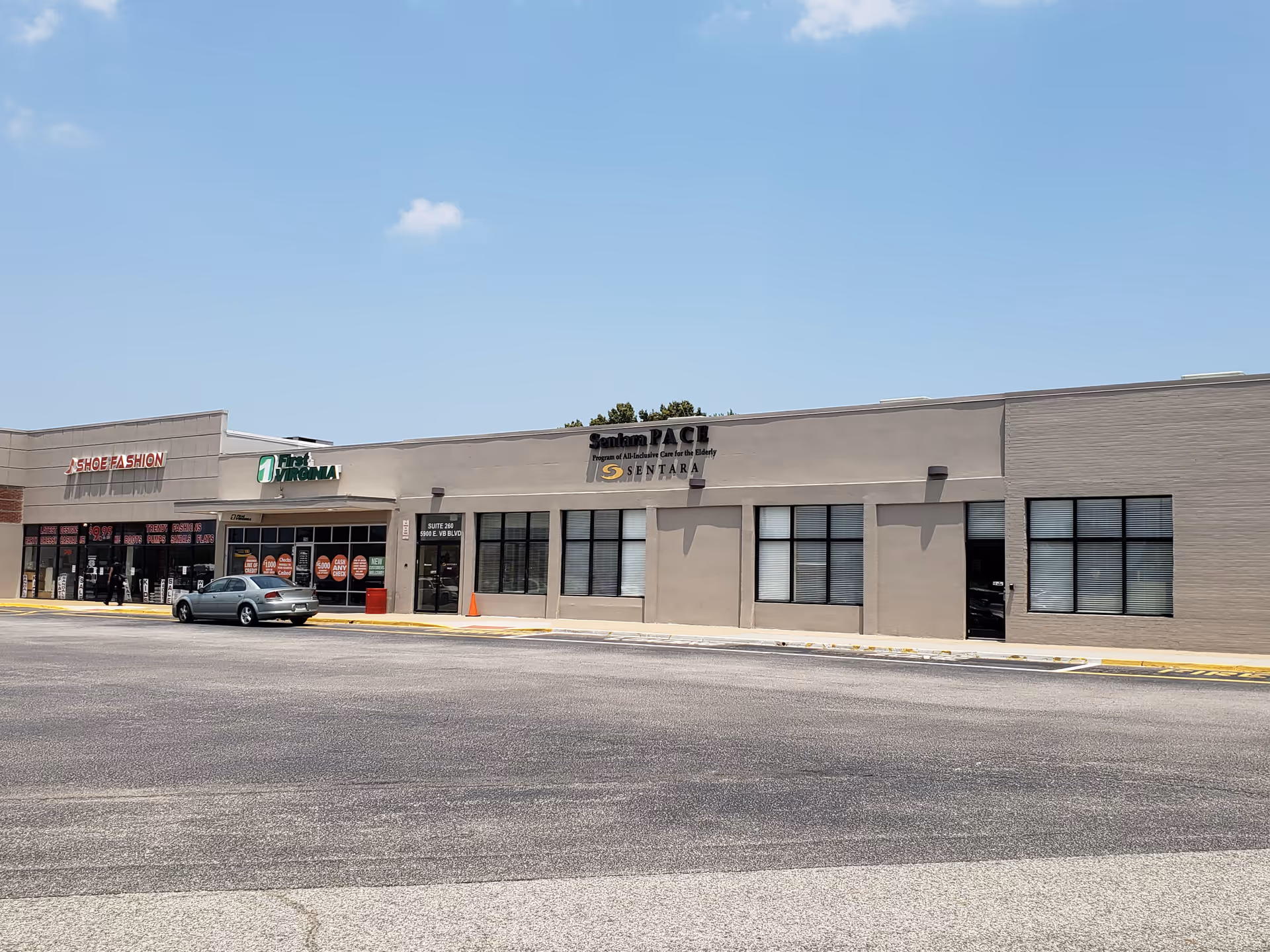 Exterior view of a strip mall with Sentara PACE signage and storefronts.