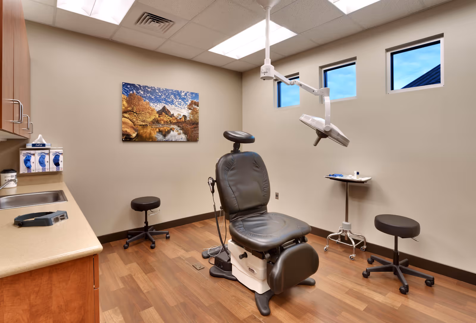 A clinic-style examination room with a dental chair and medical equipment.