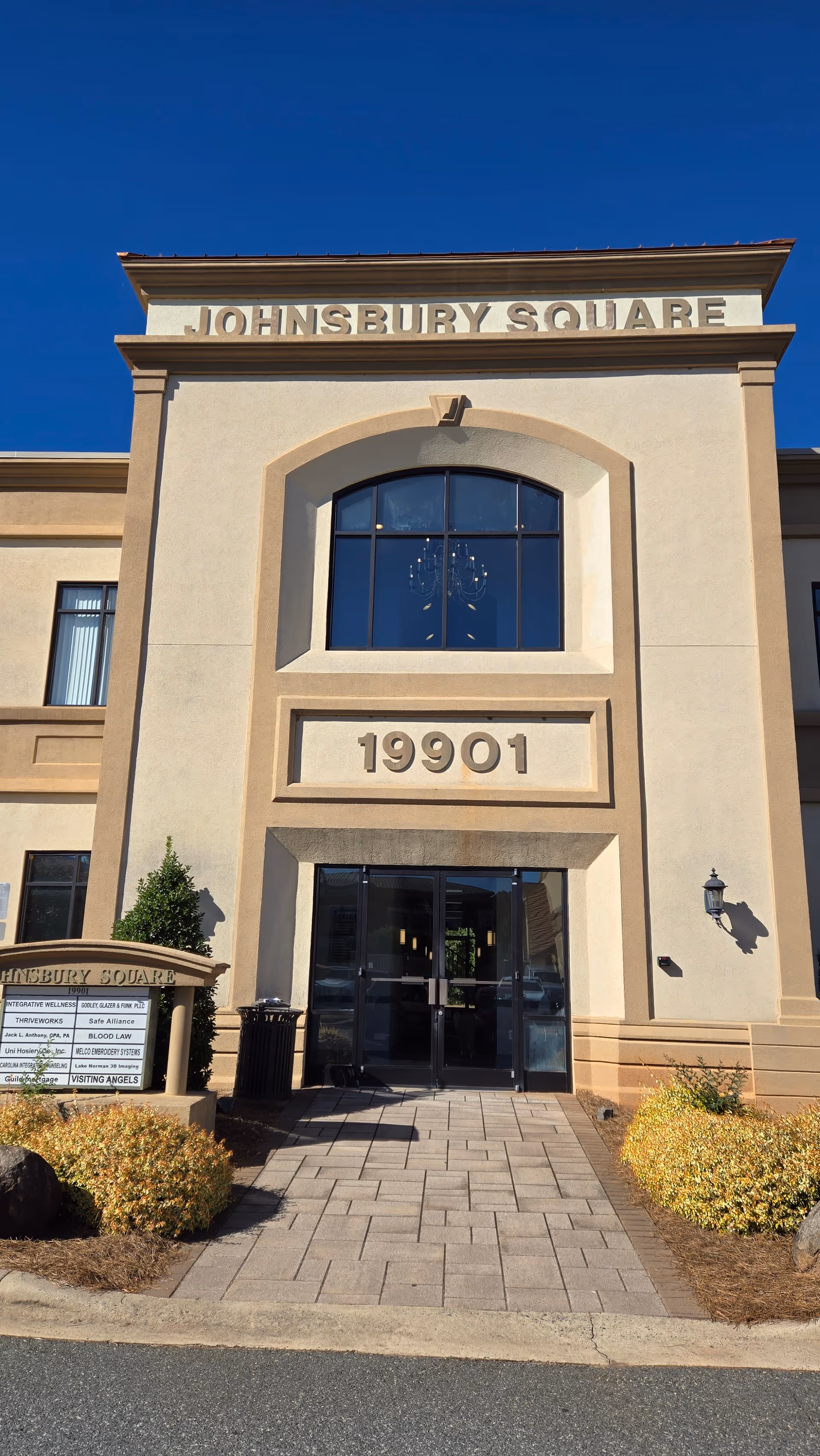 Front entrance of a beige facility with JOHNSBURY SQUARE sign and address 19901.