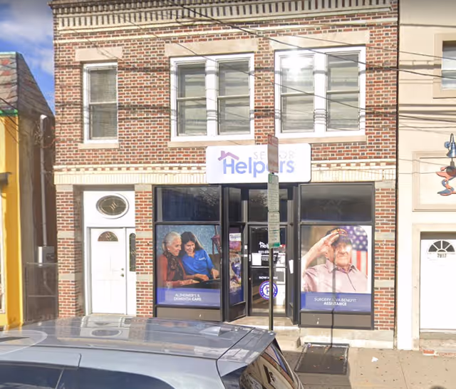 Brick storefront of Senior Helpers with large posters in display windows.