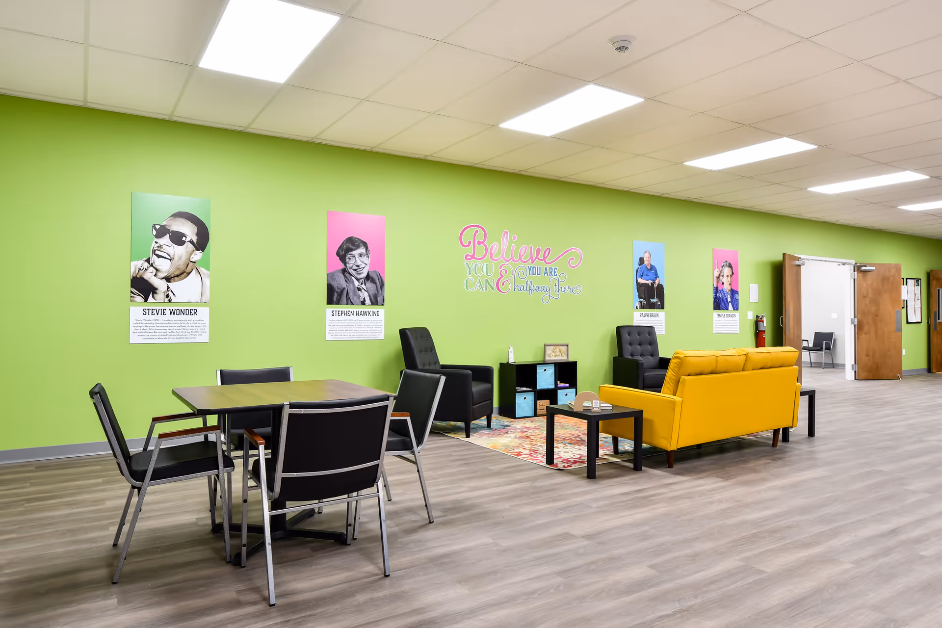 Bright lime-green lounge with yellow sofa and seating area in a senior facility.
