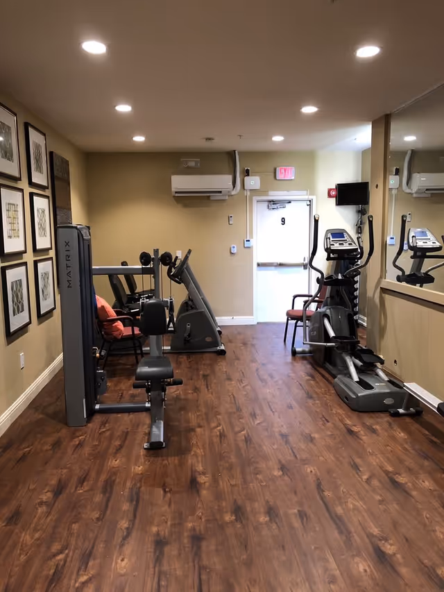 A small fitness room in a senior facility with treadmills and exercise machines.