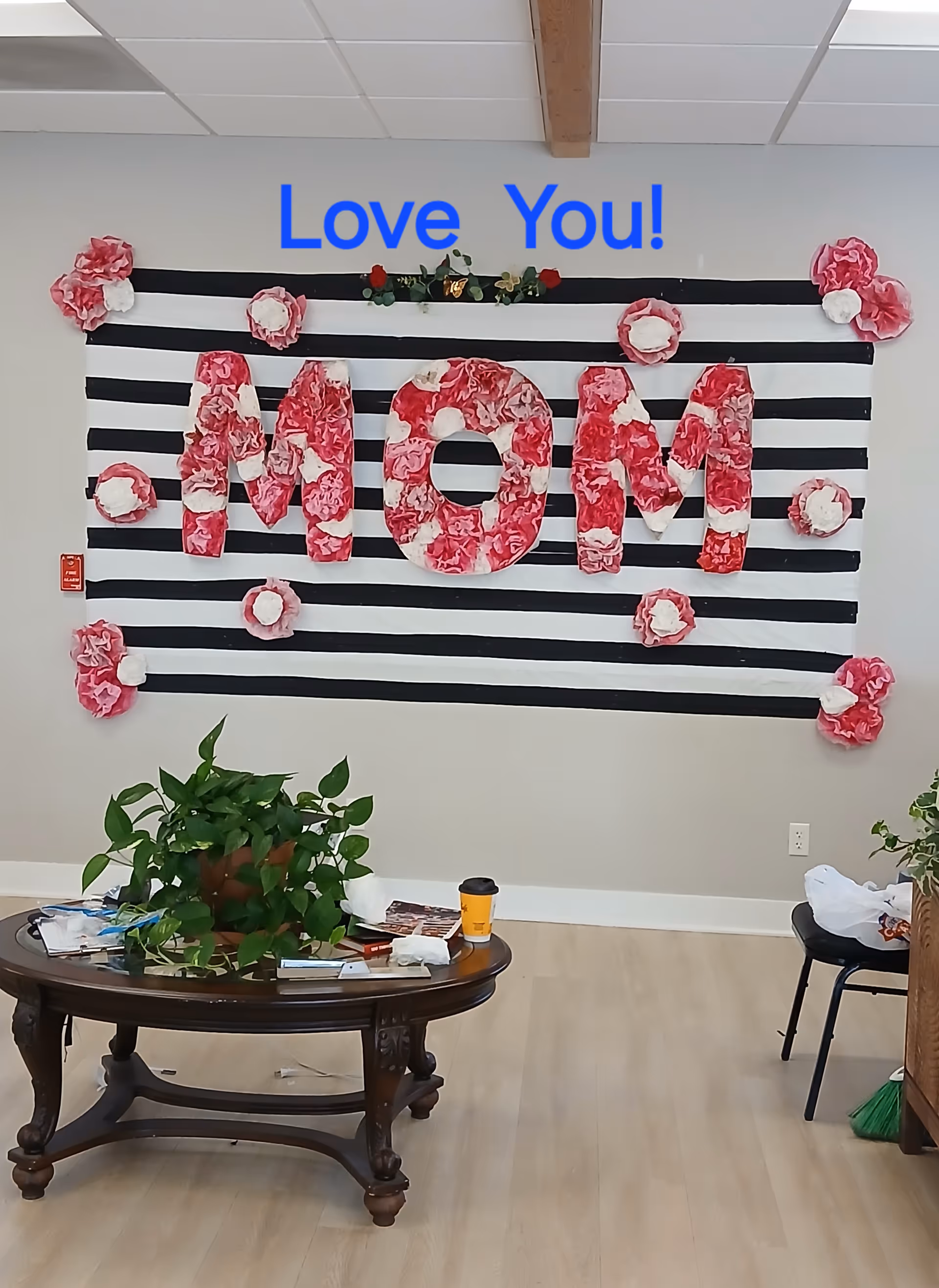 Indoor lobby with striped wall art spelling MOM in pink flowers and 'Love You!'
