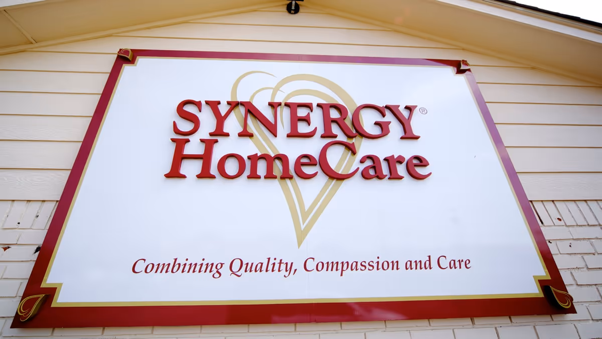 Exterior building facade featuring a large SYNERGY HomeCare sign with tagline.
