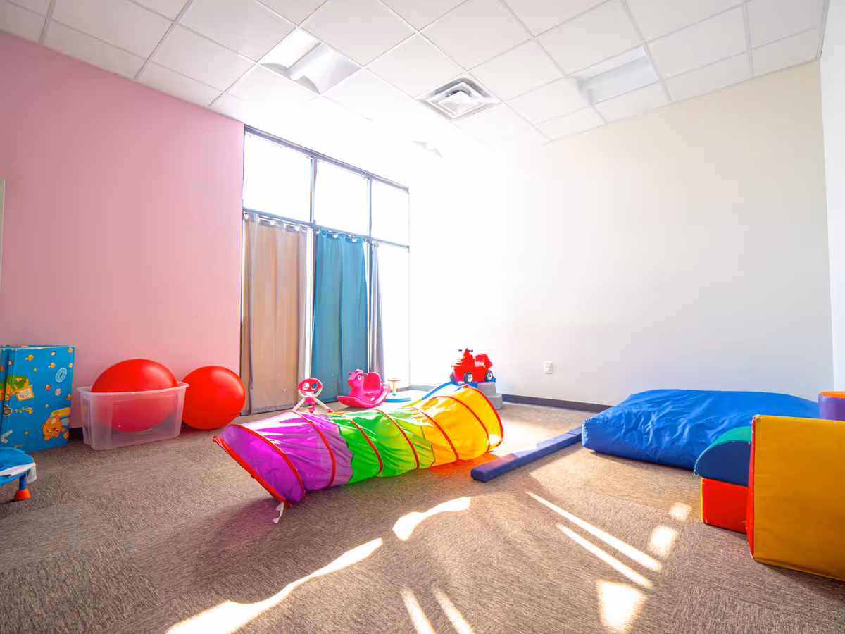 Colorful indoor play area with soft foam toys and bright sunlight.
