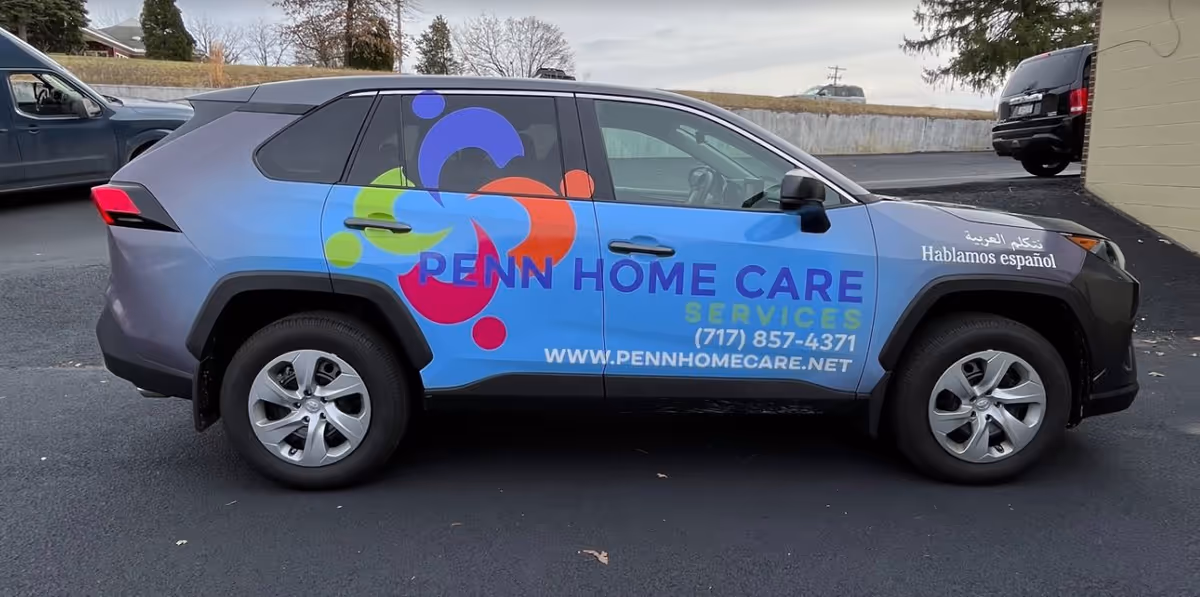 Colorful Penn Home Care Services SUV parked in a lot.