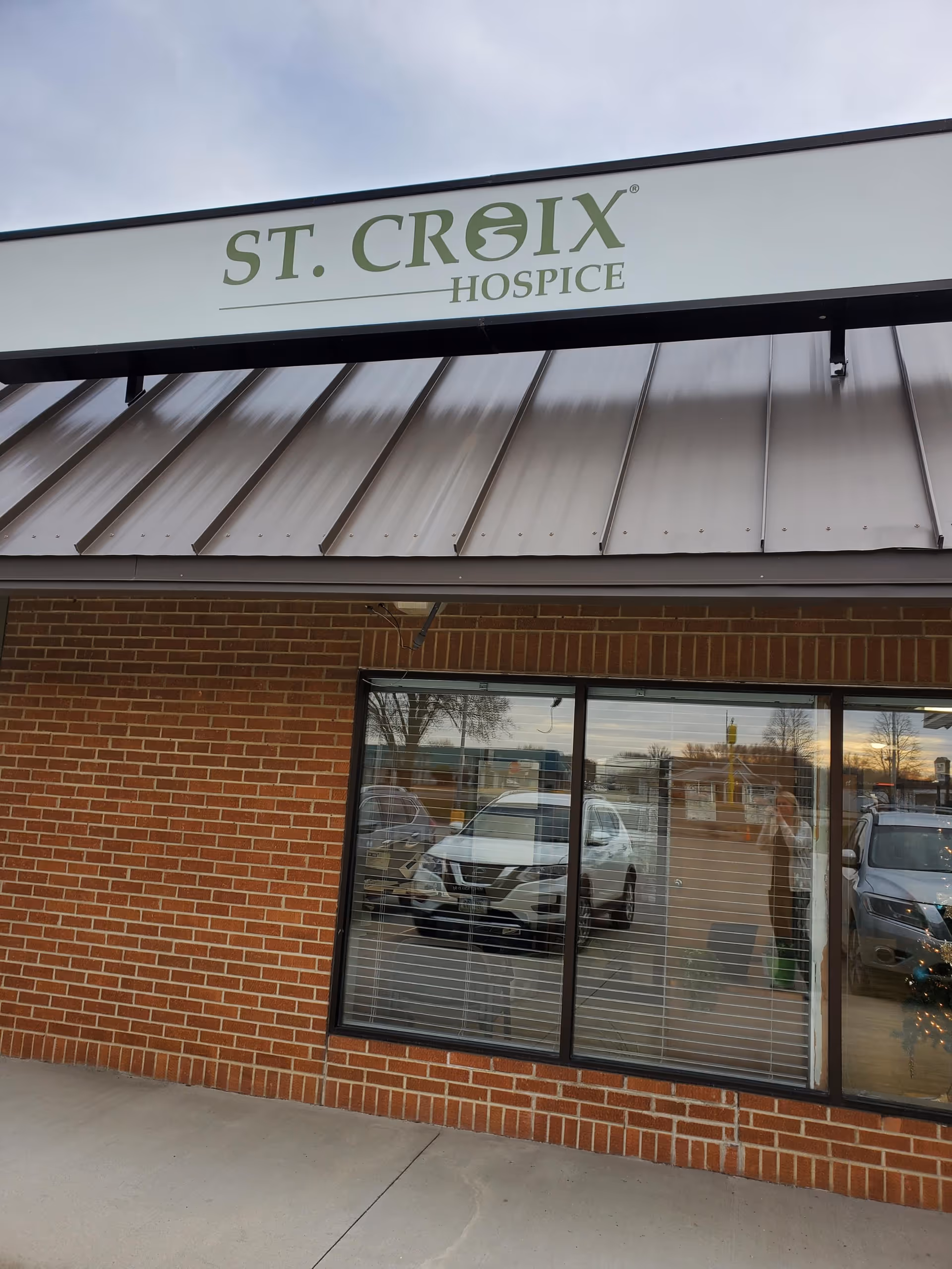 Exterior view of a brick building with a St. Croix Hospice sign and windows.