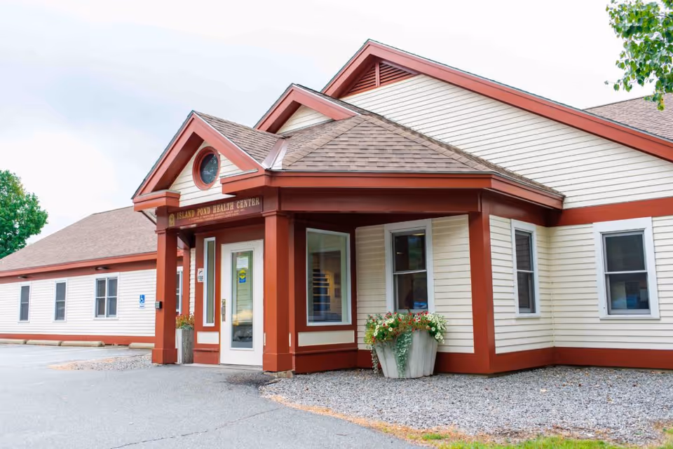 Exterior view of a single-story senior care facility with a red-trimmed entrance.