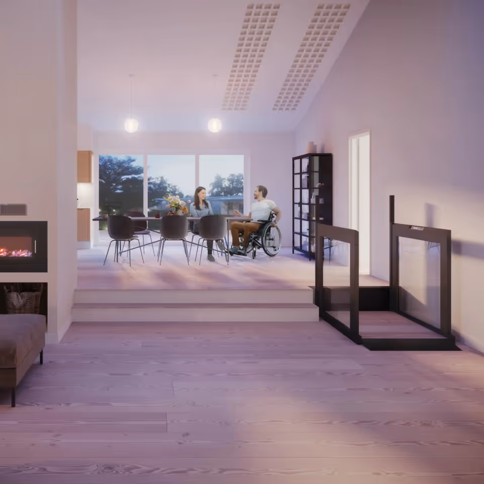Modern open interior with a dining table and a resident in a wheelchair.