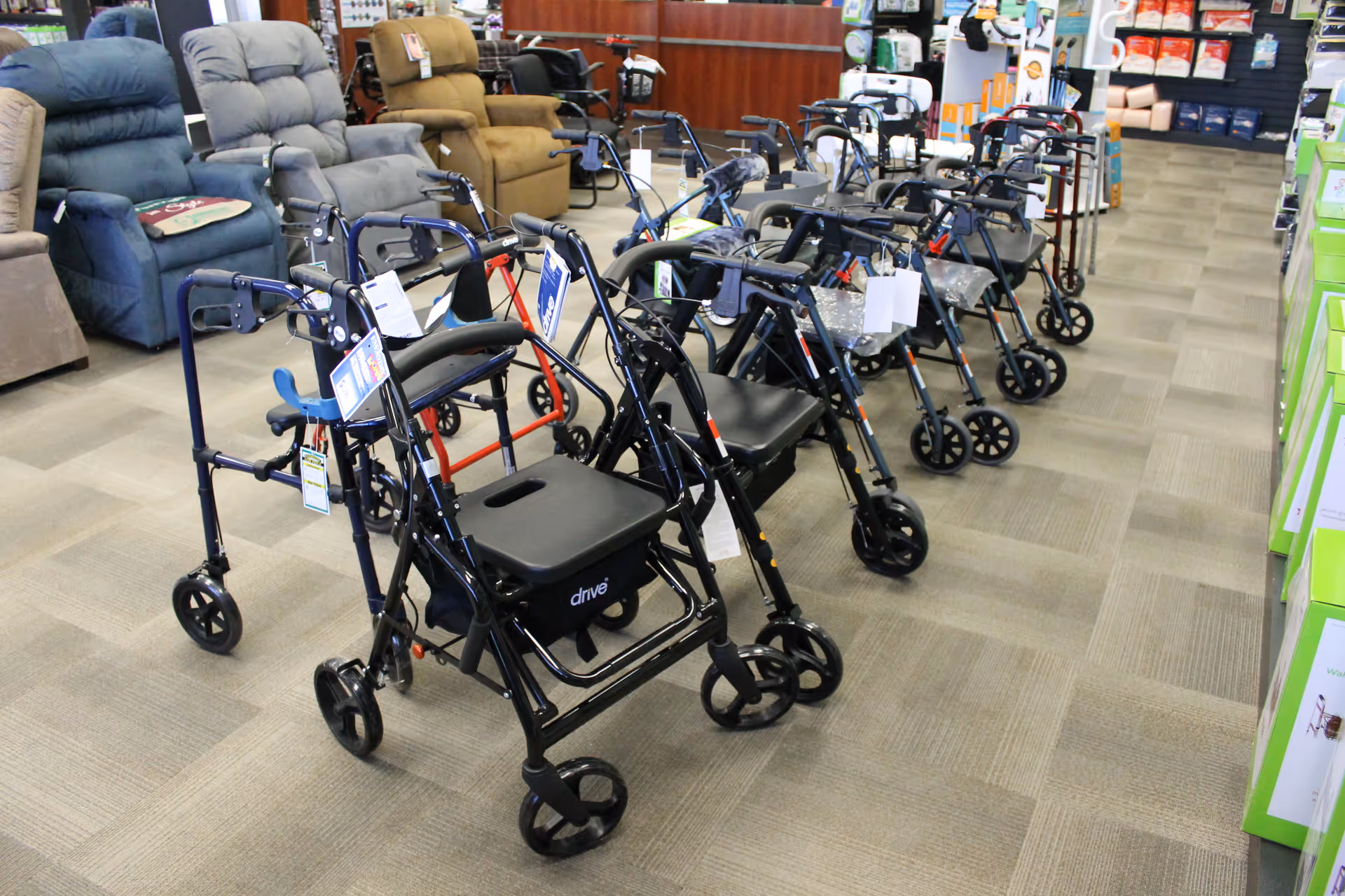 Rows of mobility walkers lined up in a showroom with seating at the back.