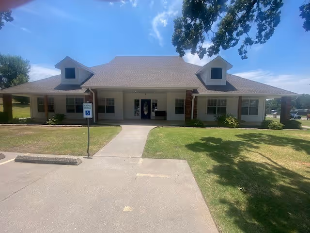 Front view of a single-story senior living facility with a central entrance.