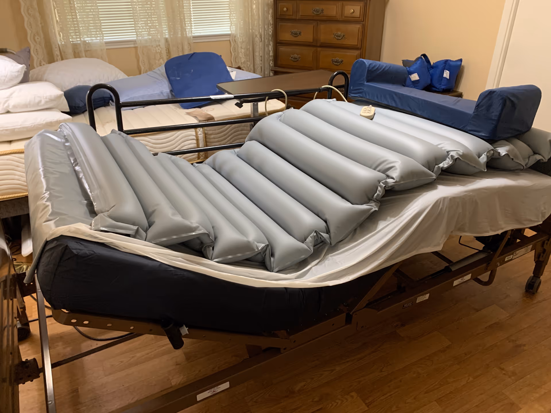 Hospital-style adjustable bed with side rails in a furnished patient room.