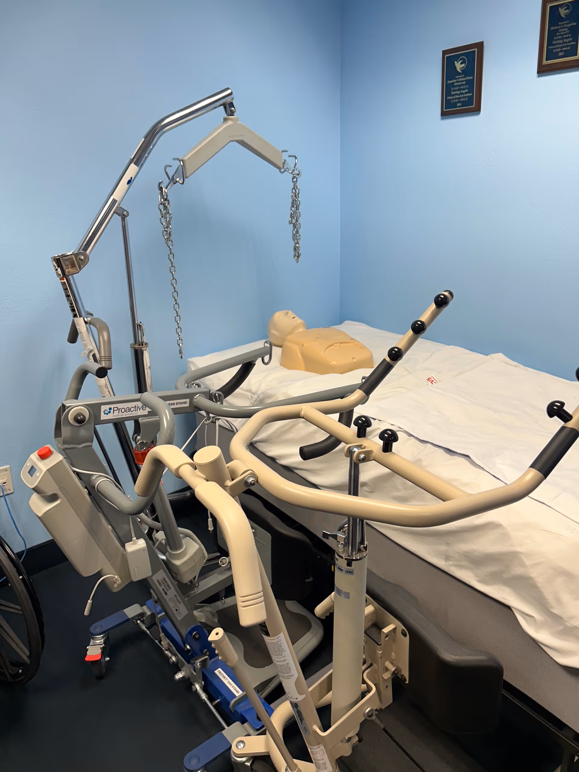 Blue-walled room featuring a hospital bed and ceiling lift equipment.