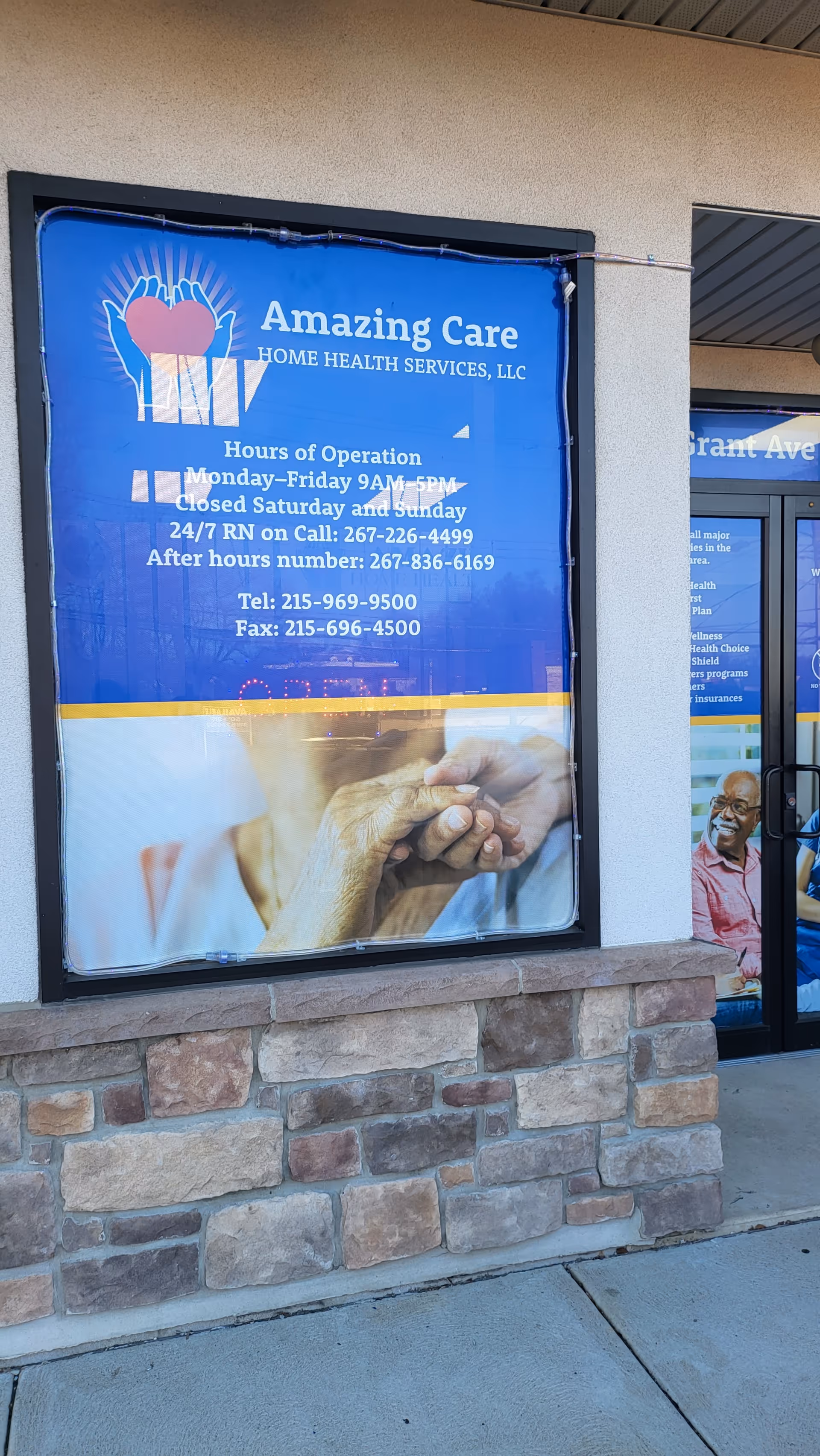 Exterior storefront with large blue Amazing Care sign on stone facade