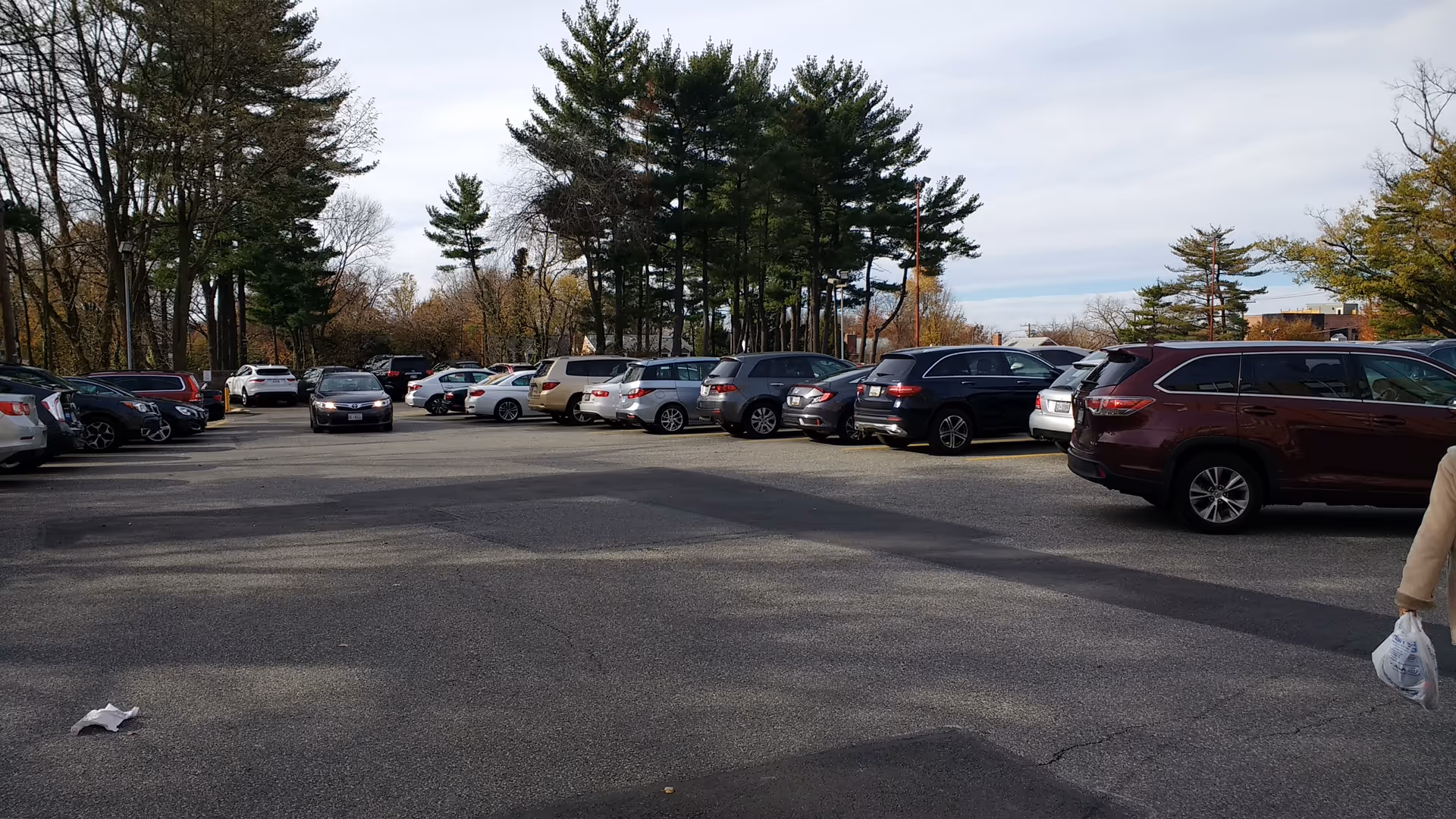 Parking lot outside Rodman's senior living facility with many parked cars and trees.