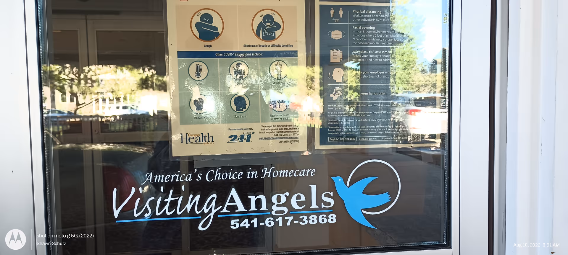 Glass entrance door displaying Visiting Angels signage and health posters.
