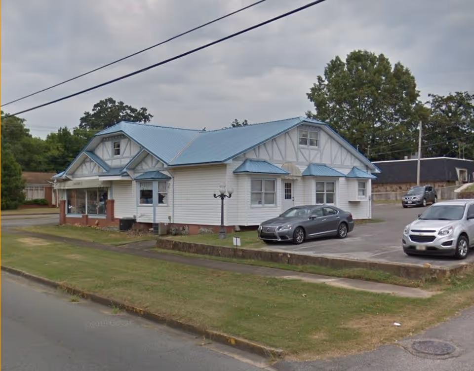 Lincare building with blue roof and parked cars on a street.