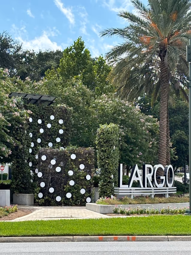 Exterior entrance with decorative wall, white circles, and large LARGO sign.