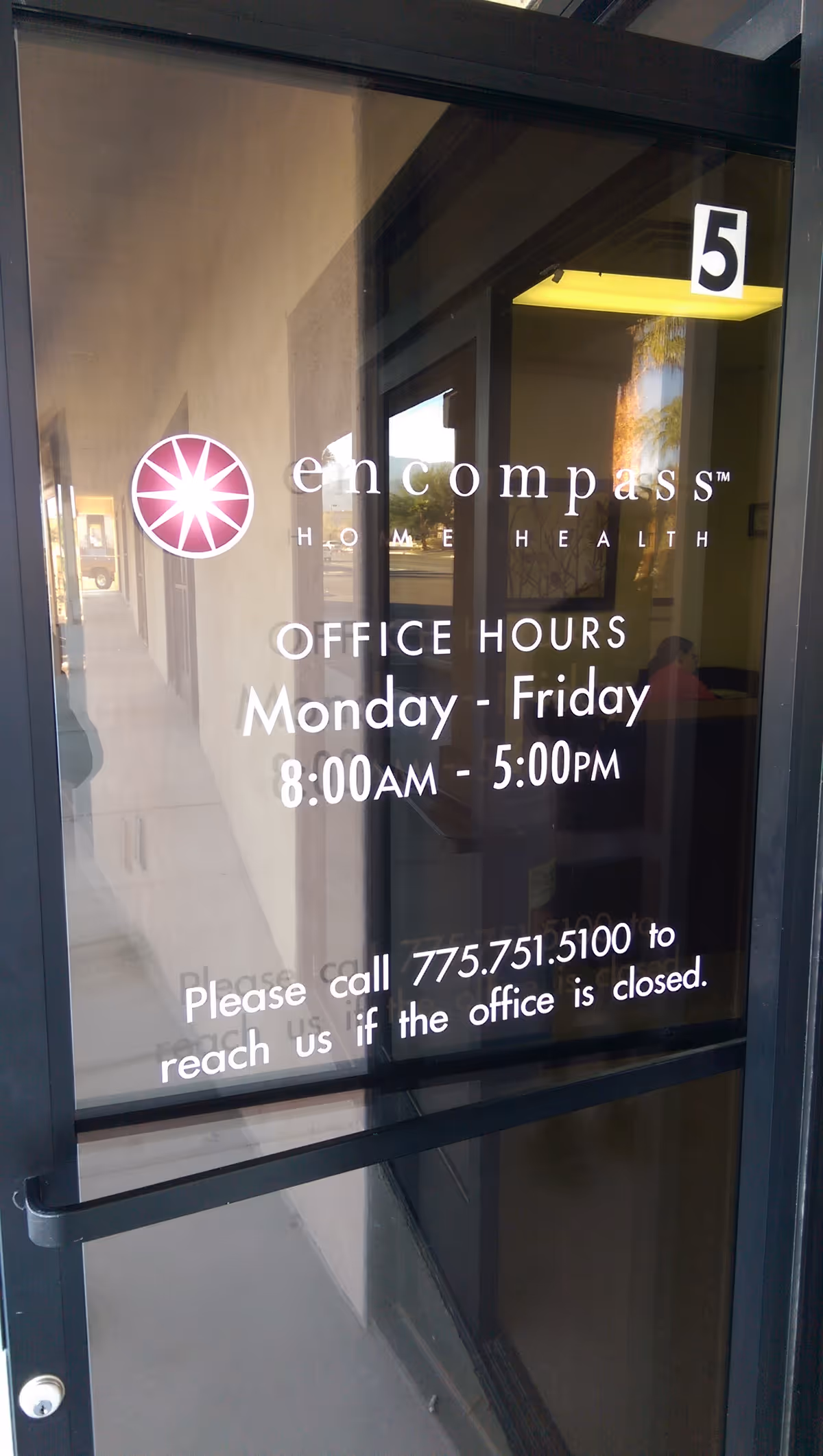 Glass entrance door with Encompass Home Health logo and office hours displayed